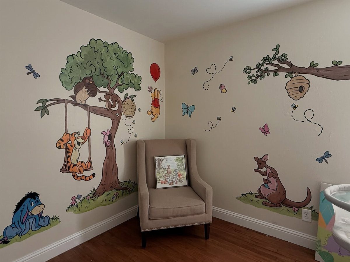 Nursery room with Winnie the Pooh wall decals and a tan armchair.