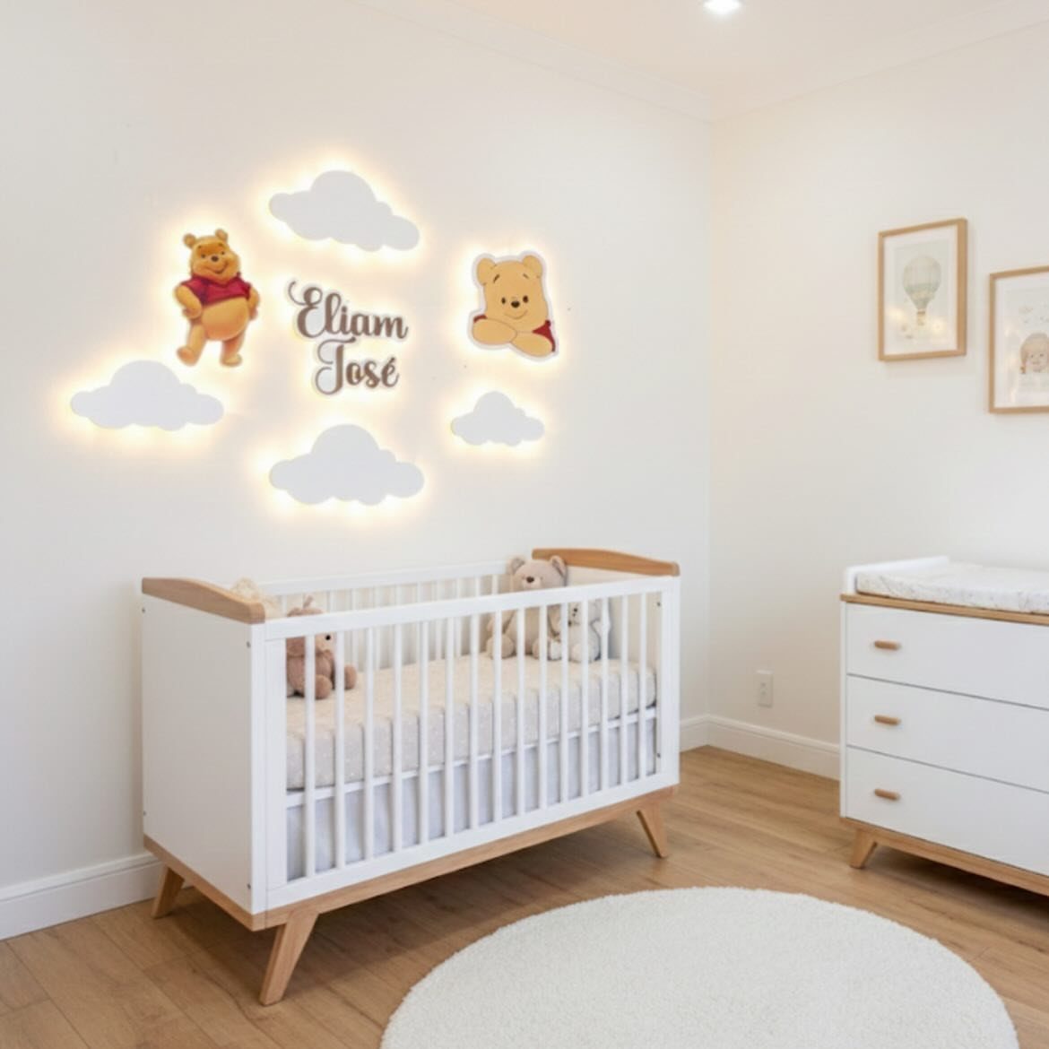 Nursery with a white crib and glowing cloud wall lights featuring Winnie the Pooh