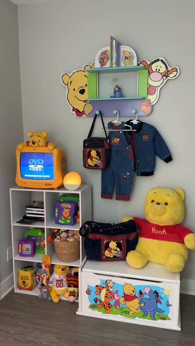 Winnie the Pooh themed children's room with plushies, toy chest, and wall decor.